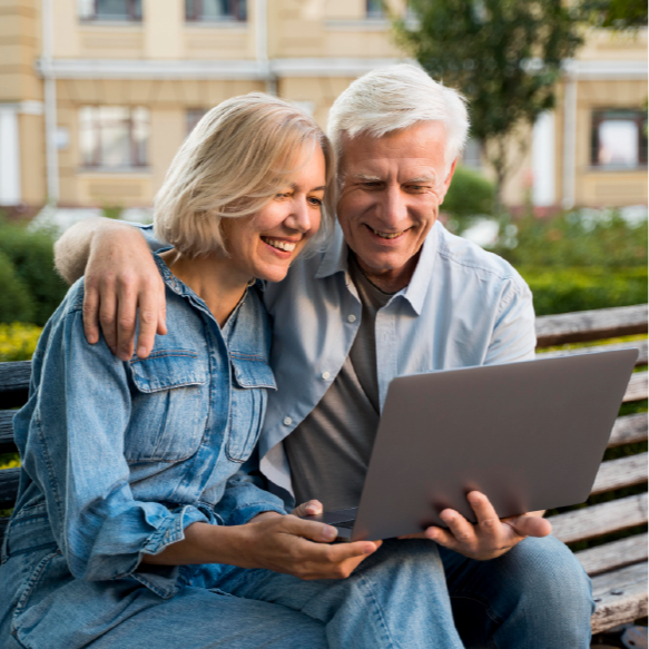 Baby boomer couple reviewing a senior relocation plan on a laptop with compassionate move management support in Columbus, Ohio